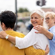 Three women smiling while walking together outside