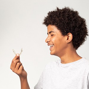 teen boy holding Invisalign TEEN tray 