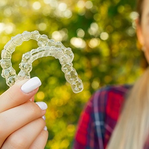 teen girl holding set of Invisalign TEEN trays 